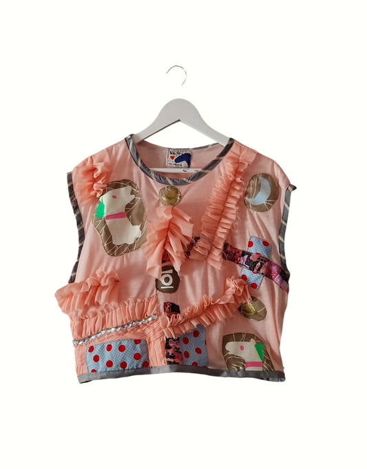 Pale pink upcycled ruffle top with horse drawings front view
Detail of childlike horse print illustration on fabric
Model wearing soft pink ruffled sustainable top
Close-up of ruffle texture and print combination
One-of-a-kind handmade artistic upcycled top