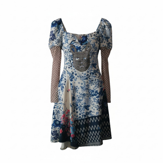 Upcycled blue and white porcelain-inspired dress front view
Detail of ornamental pattern on upcycled dress
Model wearing porcelain style sustainable dress
Close-up of blue and white vintage pattern fabric
One-of-a-kind handmade upcycled dress texture
